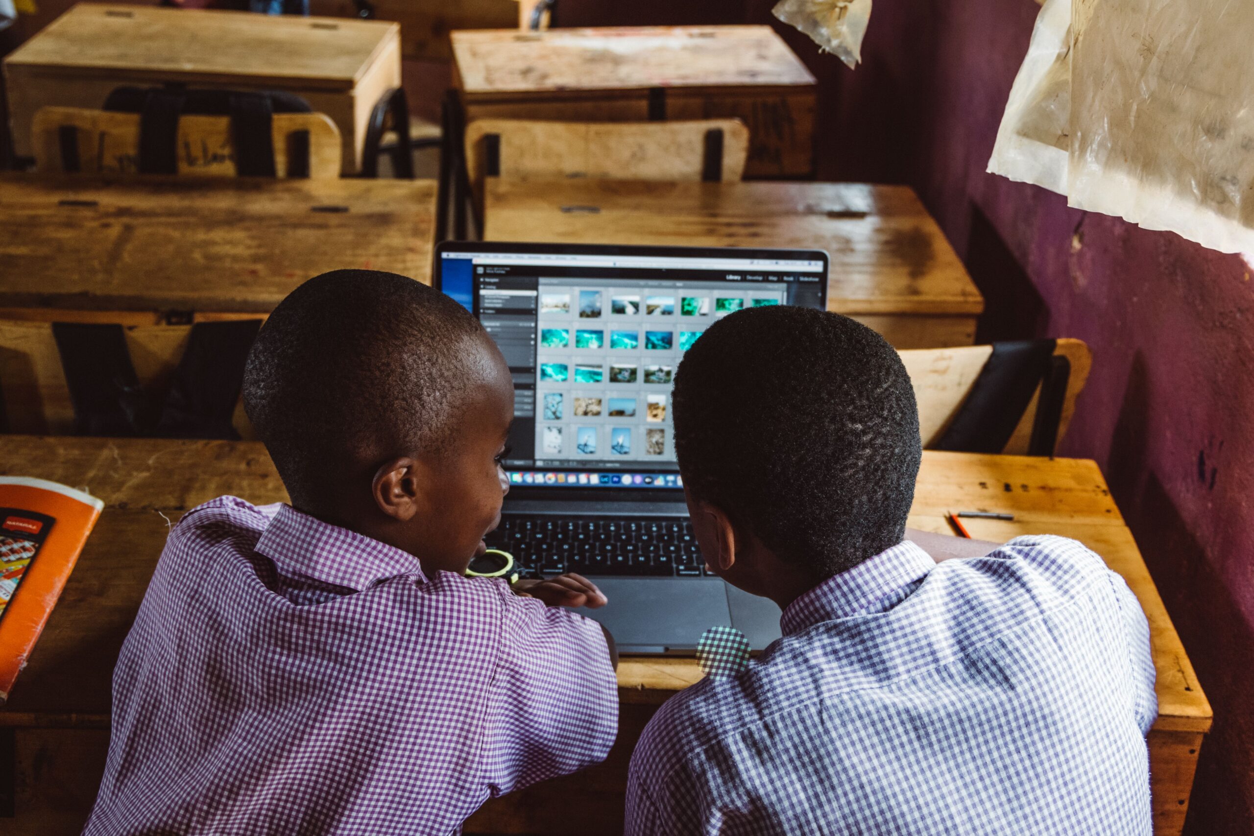 Two students using a laptop in a classroom